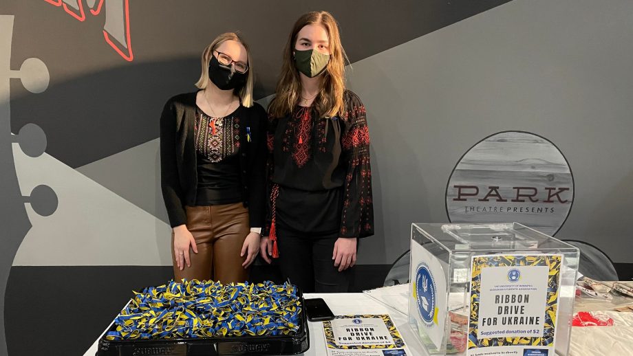 Adrianna Krawczuk和Marysa Fosty站在蓝色和黄色丝带的桌子前。