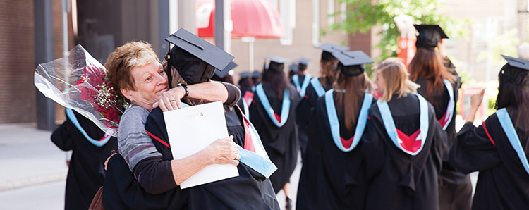 女同学在毕业典礼上拥抱学生，学生们穿着华服