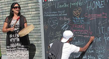 Drummer and a person writing on an outdoor chalkboard